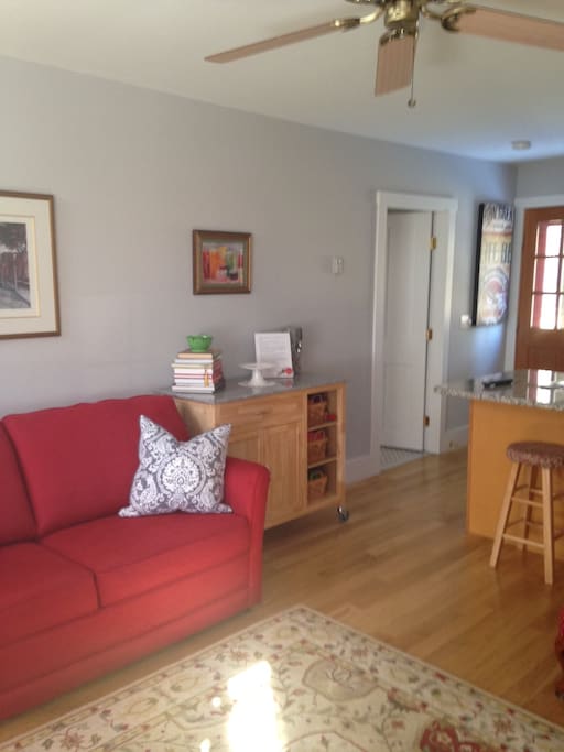 View from living space into kitchen area, doorway to bathroom and bedroom to the left.