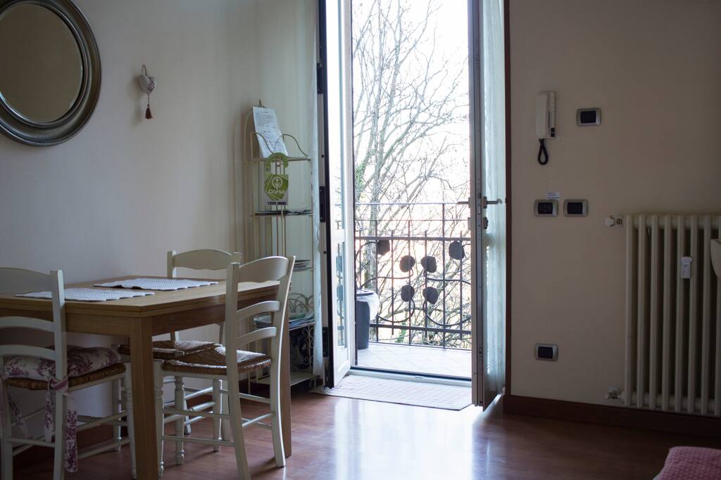 Il soggiorno con l'ingresso sul balcone e la splendida vista sulle colline e le montagne / The living room with the wonderful view