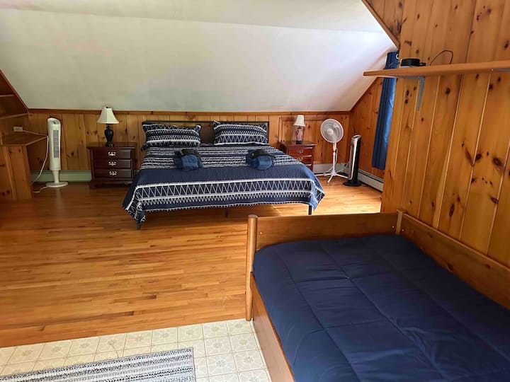 Uno de los dos dormitorios de arriba. Una cama tamaño king y una cama nido, con dos camas individuales, en la misma habitación. Cortinas oscuras para que puedas dormir si lo deseas. Armario y vestidor empotrado. Máquina de ruido blanco en el estante, en caso de que a los niños (¡o a los adultos!) les guste usar una. 