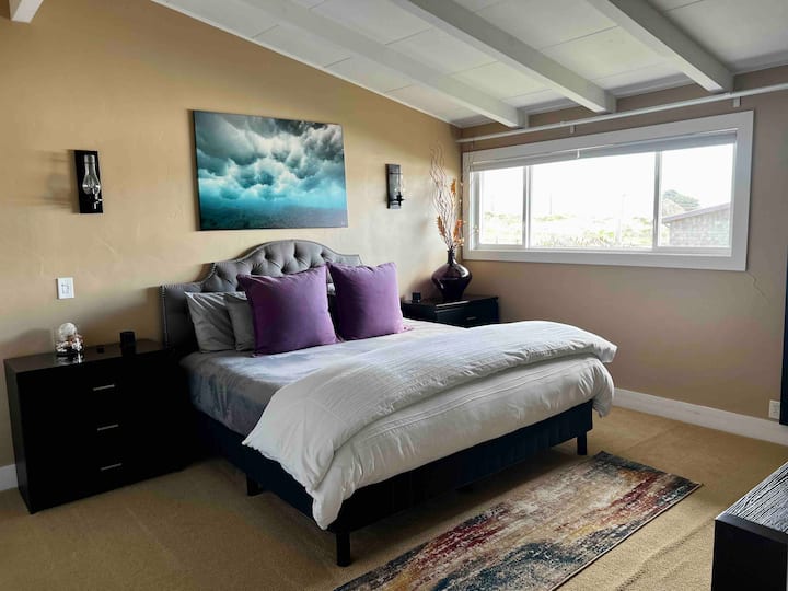 Втора главна спална соба со брачен кревет и поглед кон океанот.