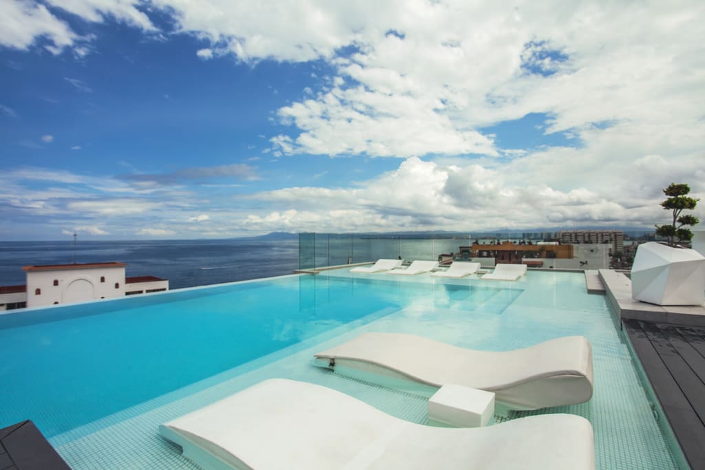 Breathtaking views from rooftop deck featuring infinity pool, two large hot tubs, and bar/lounge areas