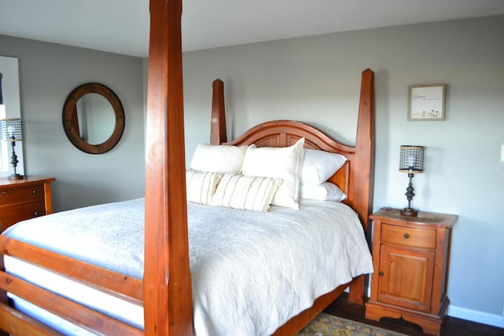 The four poster queen bed is made up with comfy linens for groups booking for 1-2 guests.
