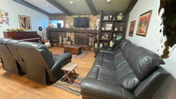 Living room area with leather recliners, massage chair and piano. 