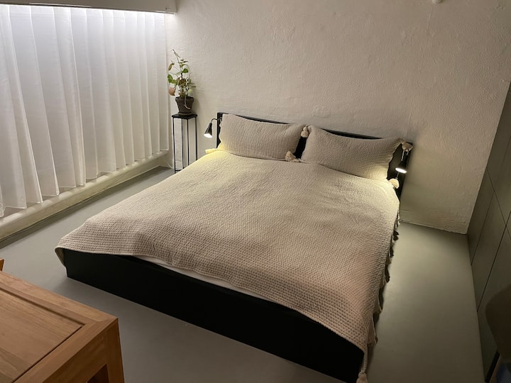 Chumba cha wageni katika ghorofa ya chini na kitanda cha watu wawili.