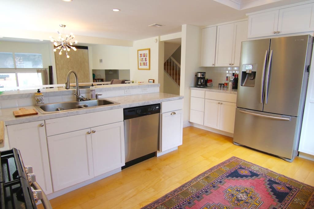 Large kitchen with marble countertops, gas range, dishwasher, all cooking supplies