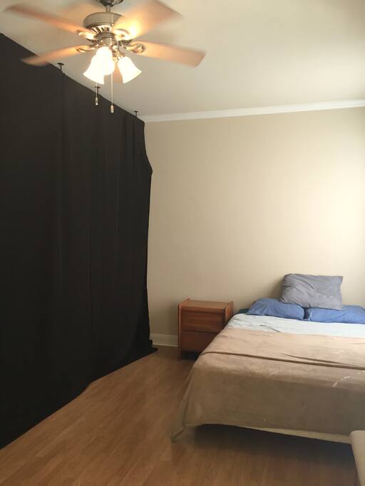 The room has no door, and is separated by a black curtain .