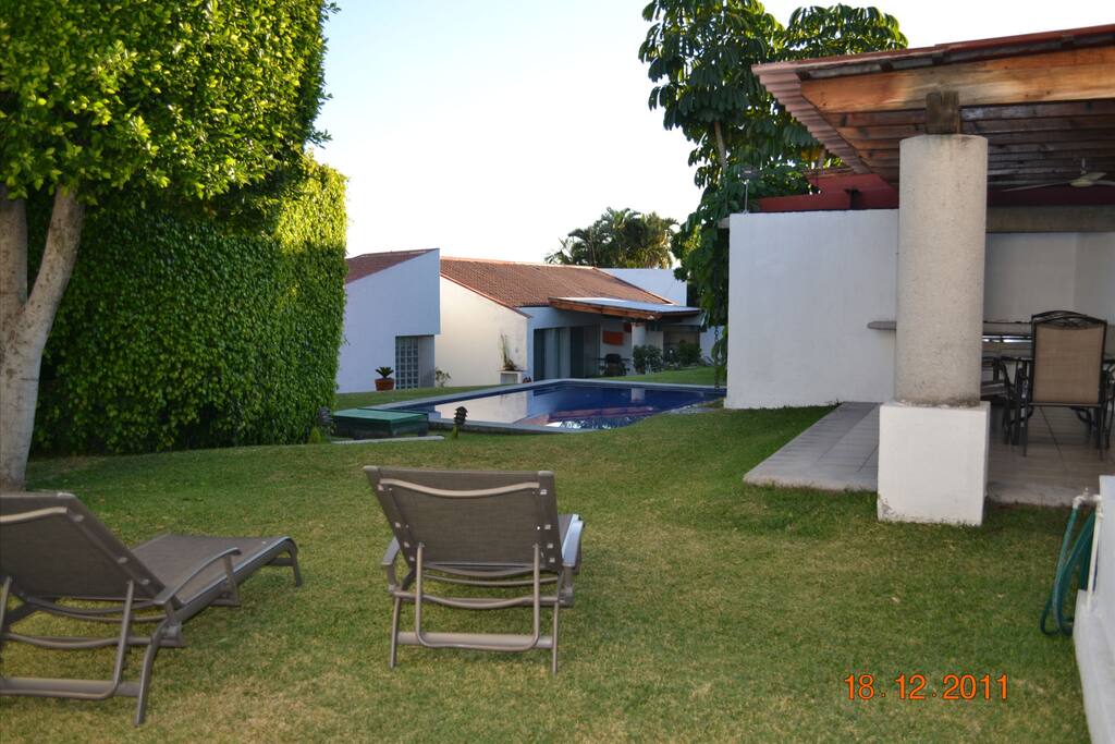 Terraza con asador y pequeño espacio de jardin con alberca compartida con 6 casitas