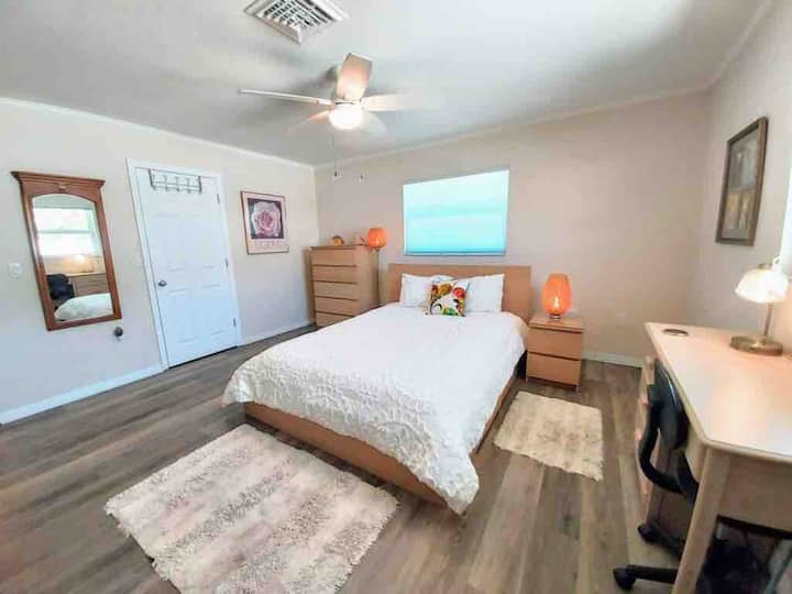 The spacious bedroom with walk-in closet, dresser, table, nite table & desk & table w/ chairs and large private TV.