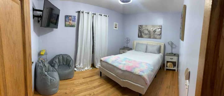 Dormitorio queen apto para niños con una luz controlada a distancia regulable y un ventilador de techo, TV de 55 pulgadas.