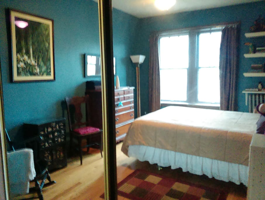 A view of most of the room from the reflection of the mirrored closet. You may stash luggage in the closet and use the top two drawers of the dresser.