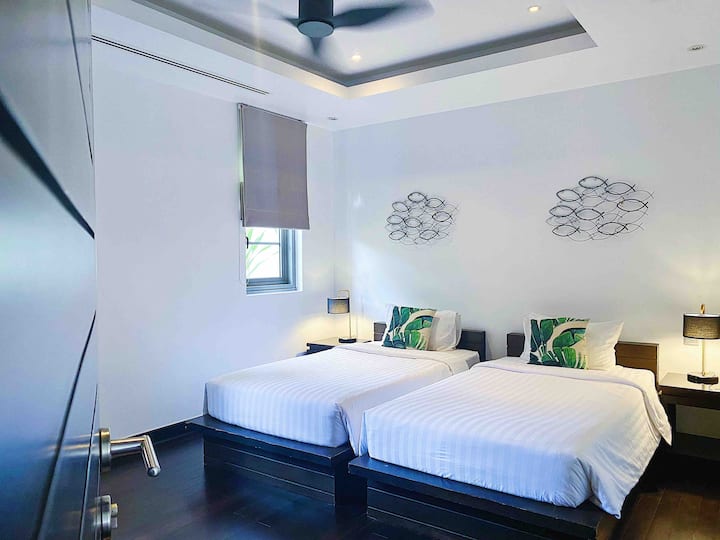 חדר שינה נעים 2 עם 2 מיטות יחיד שניתן לחבר כדי להציע מיטה גדולה