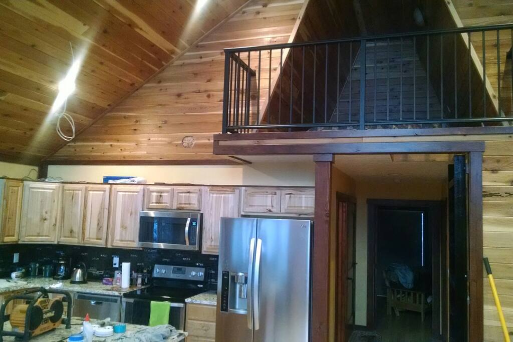 Loft above accessed by custom steel ladder overlooks the great room and sleeps 2 comfortably in a king size bed.