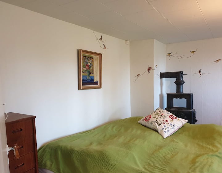 Bedroom to the north, with a wood-burning stove. There are two wood-burning stoves - one in the old living room and one in the bedroom.