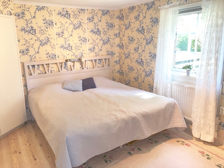 ห้องนอนที่กลมกลืนกับวอลล์เปเปอร์ลายดอกไม้สวยงามเตียงคู่ตู้ลิ้นชักตู้เสื้อผ้า