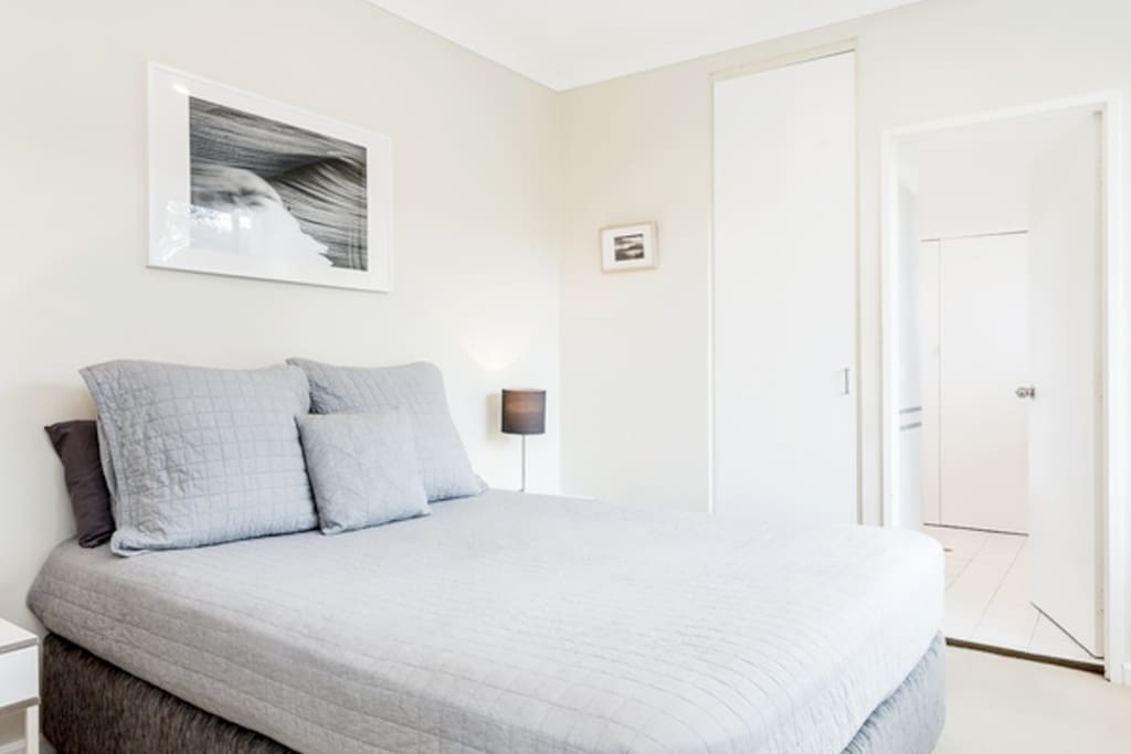 Queen sized bed with side tables with 2 full sized built in wardrobes
