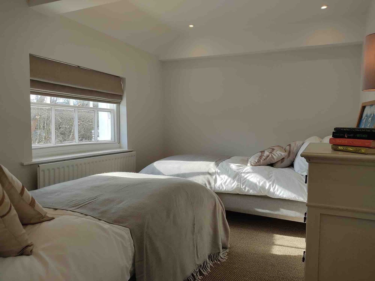 Chambre avec lits jumeaux et commode.