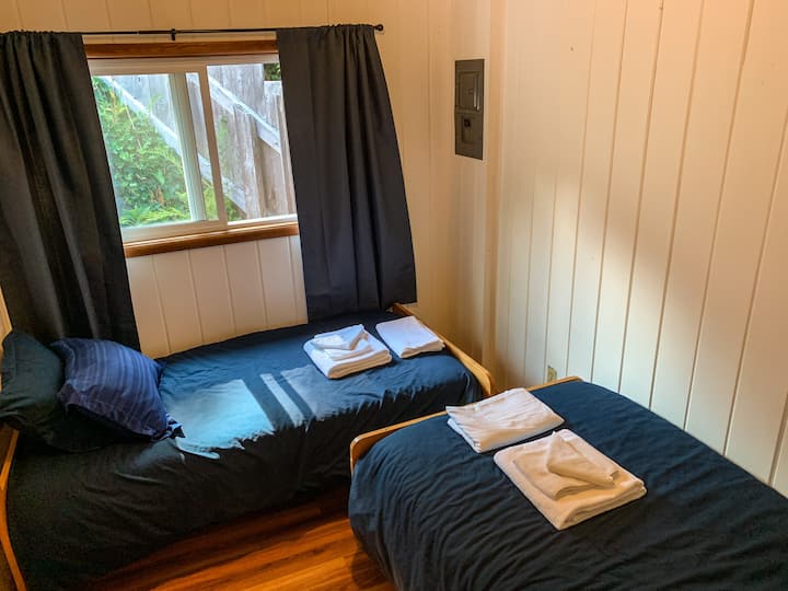 Bedroom 3 with 2 twin beds, closet, and window looking out to private back deck