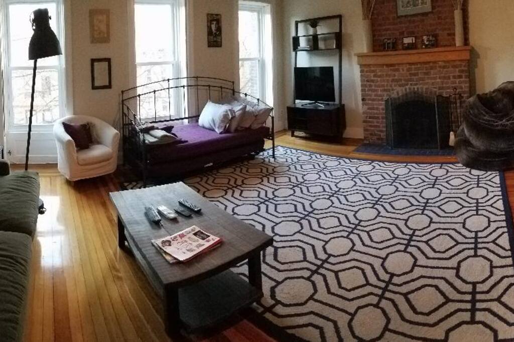 Living room - lots of light, with sofabed and two twin beds rolled away. Working fireplace, TV with cable, a DVR to record your own shows, a Blu-Ray player, and Wi-fi access.