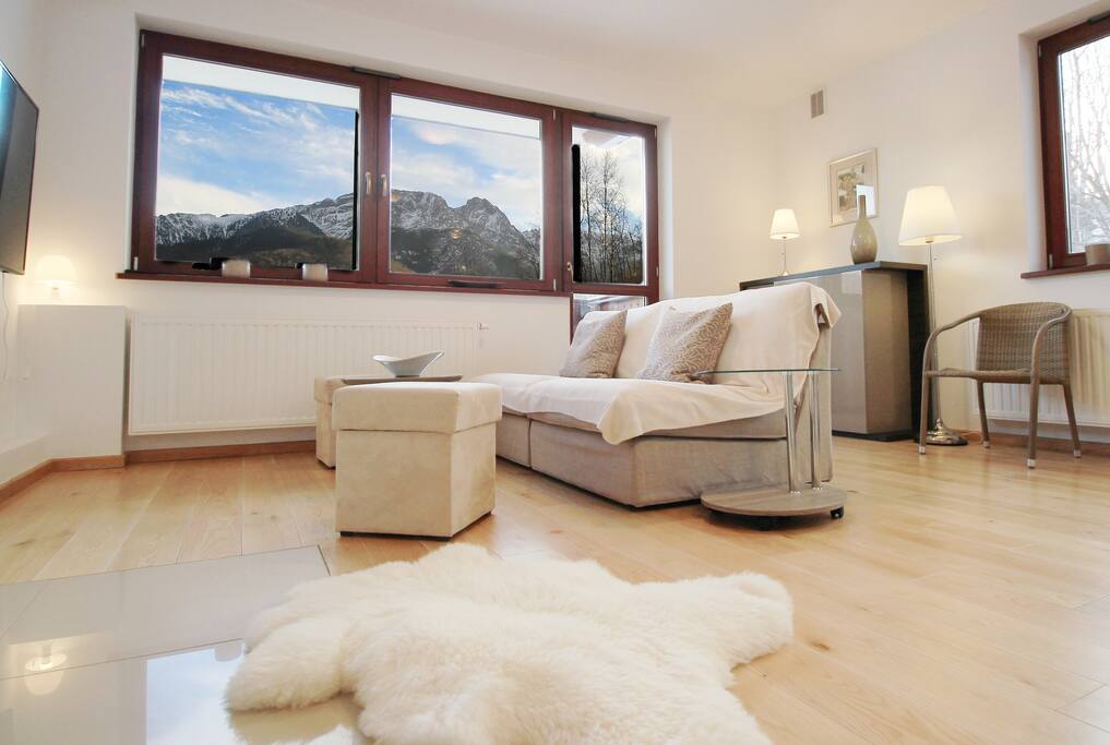 Living area with tv, fireplace, kitchen and two balconies with stunning views.