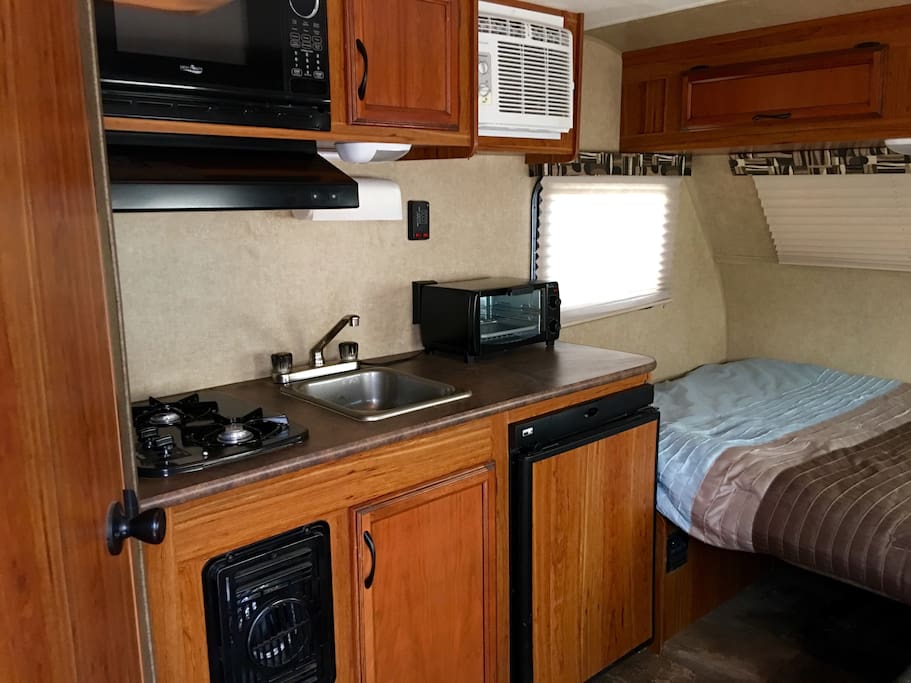 2 burners, microwave, toaster oven, sink, small fridge, pots, plates, cups and silverware.
