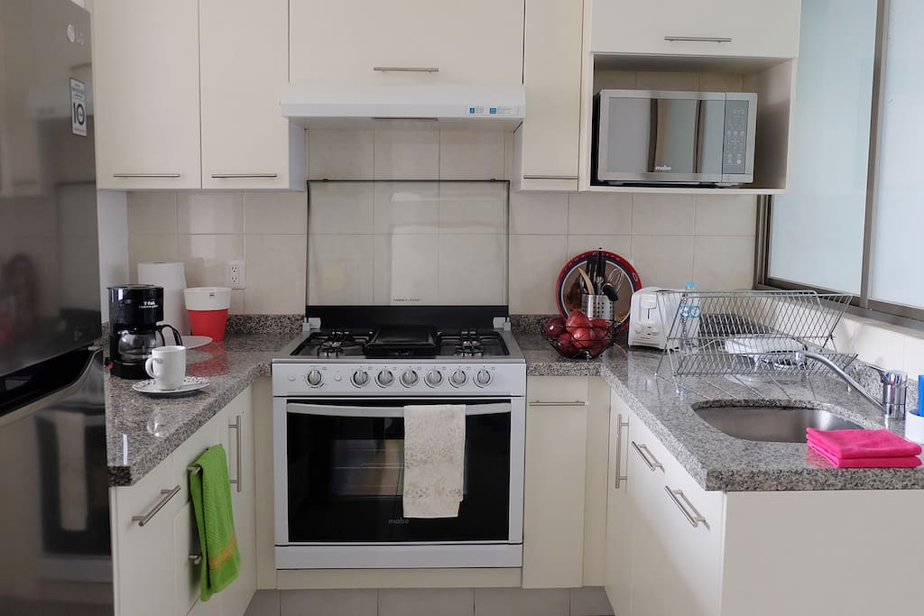 Full equipped kitchen with microwave, coffee maker, tea, dishes, utensils and toaster.