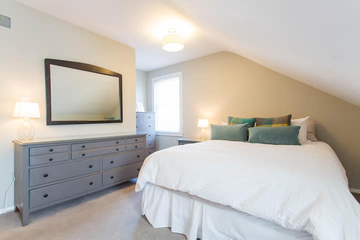 Spacious bedroom with two dressers,  generous closet and two windows.