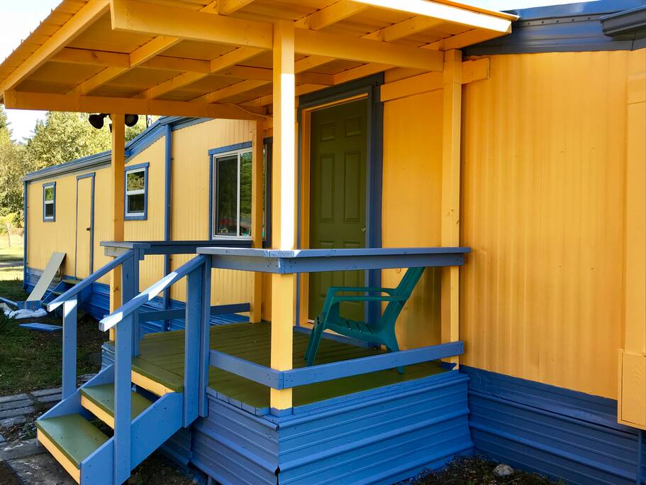 Covered porch with chairs for sitting.