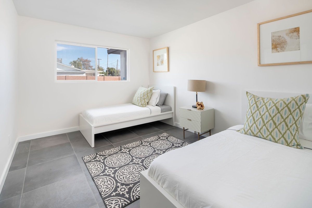 Spavaća soba za goste s 2 odvojena kreveta i radnim stolom sa stolicom za sav posao od kuće. 