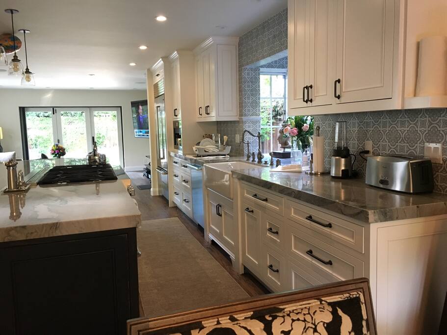 Newly remodeled kitchen complete with 10ft island, espresso machine/coffee maker, gas range, steam oven, warming drawer, and hood that automatically rises from the island and all new appliances.