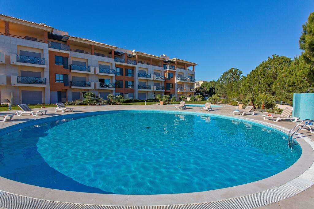 Large swimming pool with sun loungers & gardens