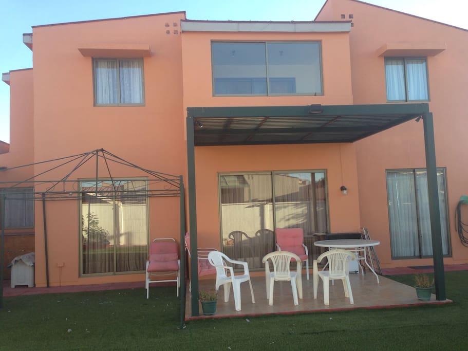 Patio, pasto sintetico, juegos para niños, con sillas mesas, terraza, iluminación