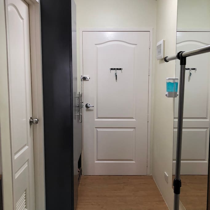the entryway's space is utilized with the shoe/utility cabinet, full length mirror and drying rack