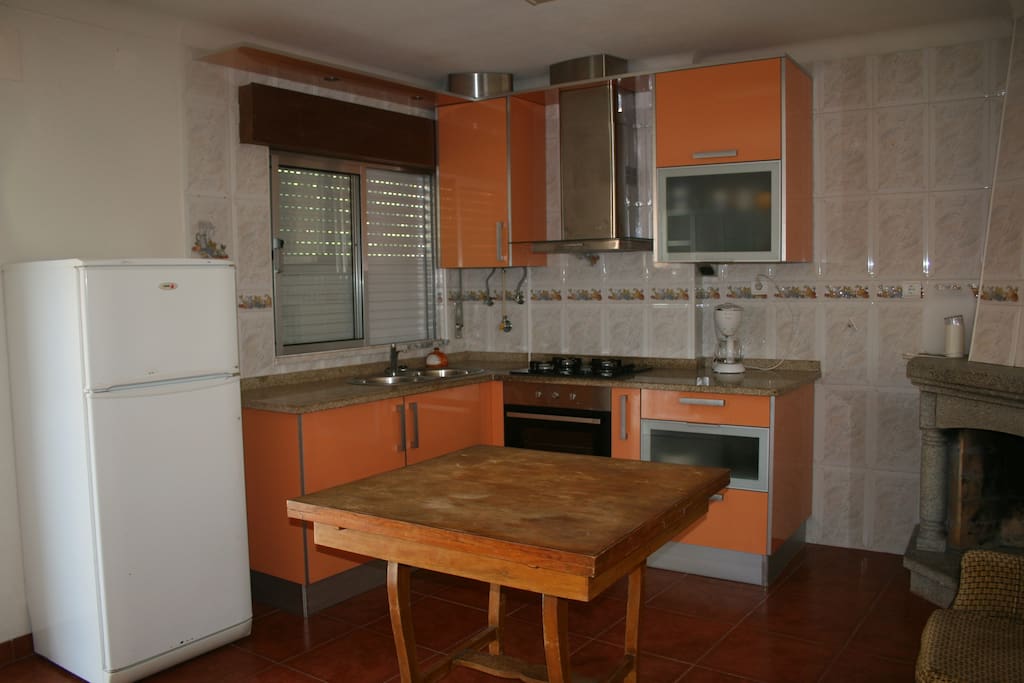 Leefkeuken met gasfornhuis, oven en koelkast/vriezer.