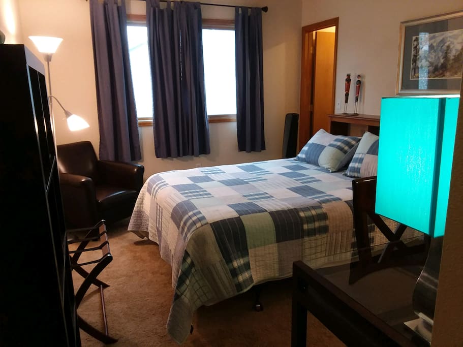 Small guest room with queen Sleep Number bed, leather chair and walk-in closet