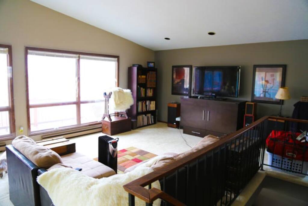 The spaceous living room features vaulted ceilings, a murphy bed and comfy couch invite snuggling as you watch the Sunset, lake fun or the TV.