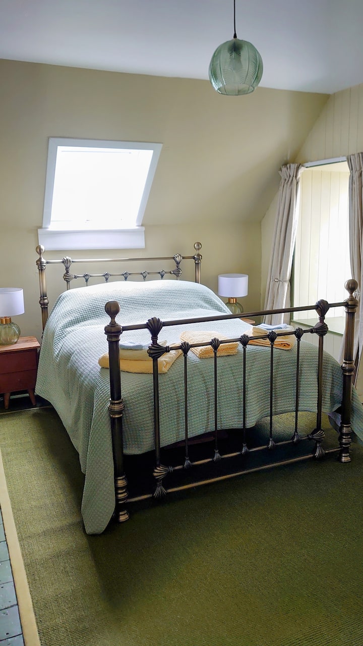 Green bedroom. One double bed. One single bed. Dressing table. Wardrobe. Chest of drawers. Beach sea and bay views and countryside views (Top Floor). 