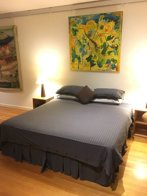 King bed with art from the gallery hanging in your room.