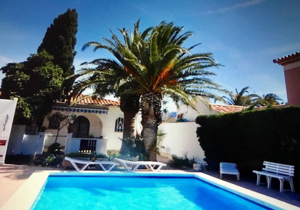 Piscina comunitaria y fachada del chalet correspondiente a este anuncio