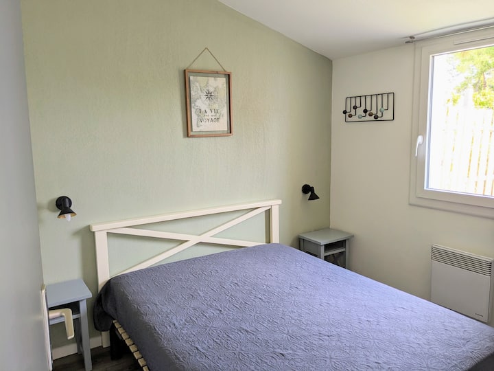 Chumba cha kulala chenye vitanda viwili na meza na kabati la nguo.