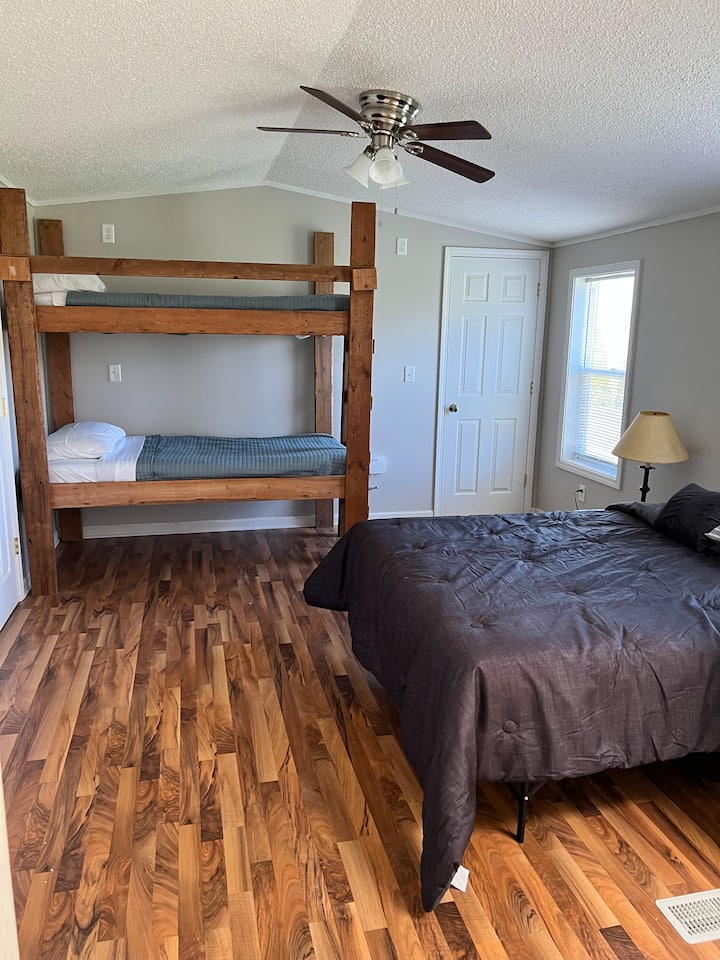 Dormitorio principal con una cama queen y una litera