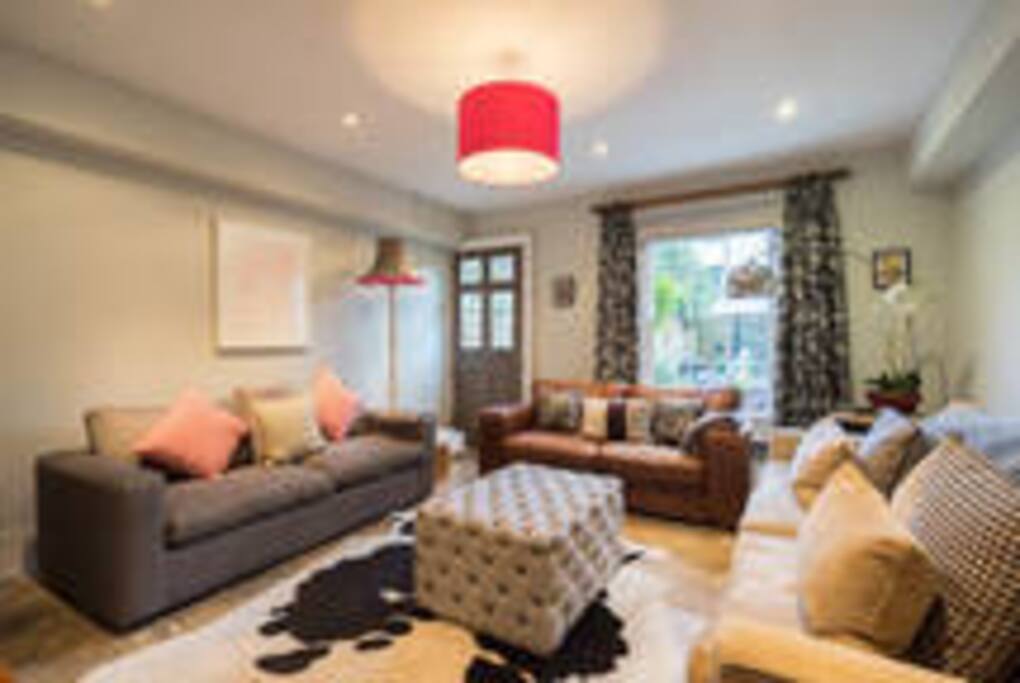 The Maisonette lounge on Garden level - please note the grey sofa on the left is now a teal coloured sofabed. Doorway out into garden.