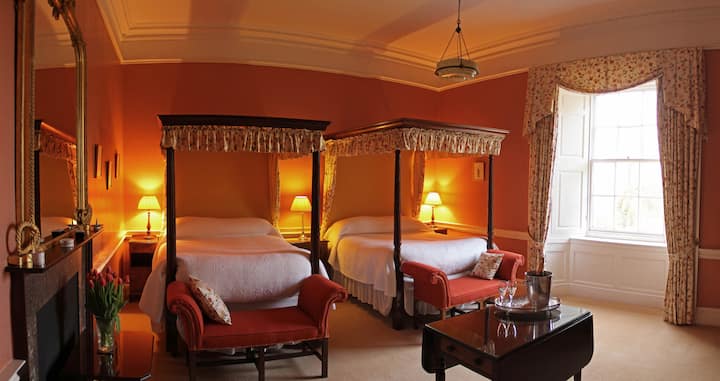 Dormitorio veneciano.  2 camas tamaño queen con dosel y baño con una gran ducha a ras de suelo y banco.