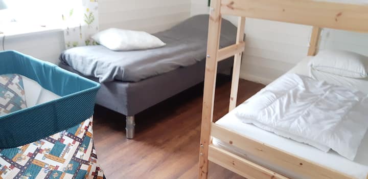 1号房-绿色房间，配有一张双层床、一张床和一张旅行婴儿床。