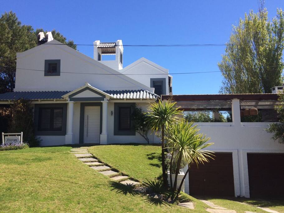 Vista frontal de la casa con dos garajes cerrados