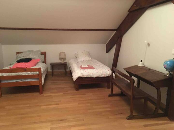 Two small beds and a small school office with children's books.