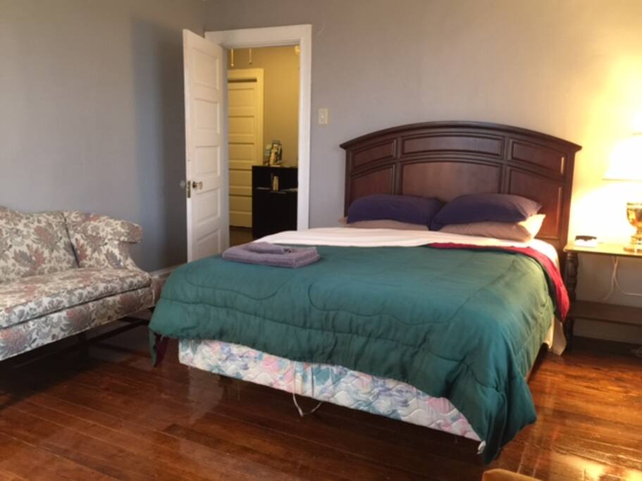 Queen size bed, sitting chair, dresser and desk with great natural light.