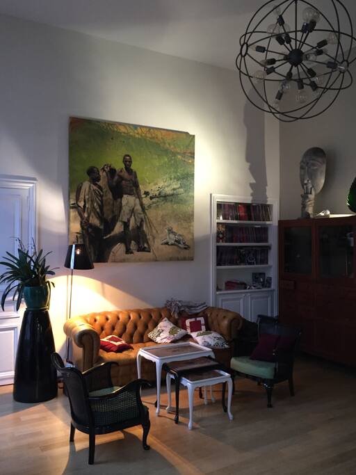 Take a seat in the living -, enjoy the high ceilings, the paintings and why not a bit of TV hidden in the buffet