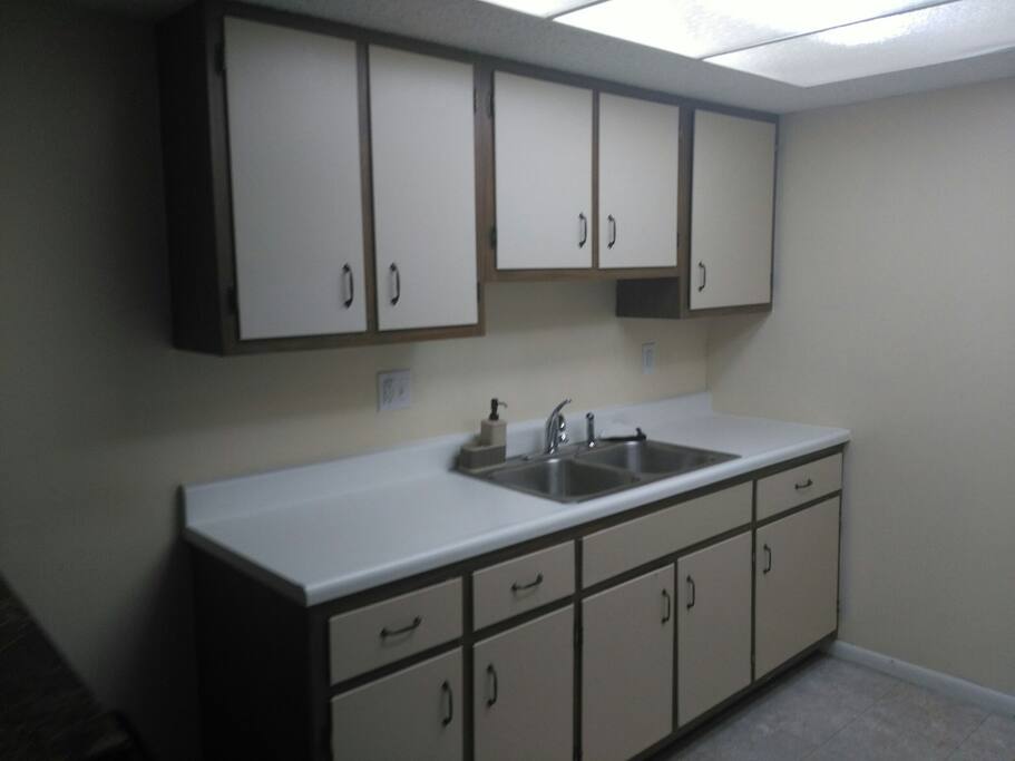 Kitchen sink and generous cabinet.
