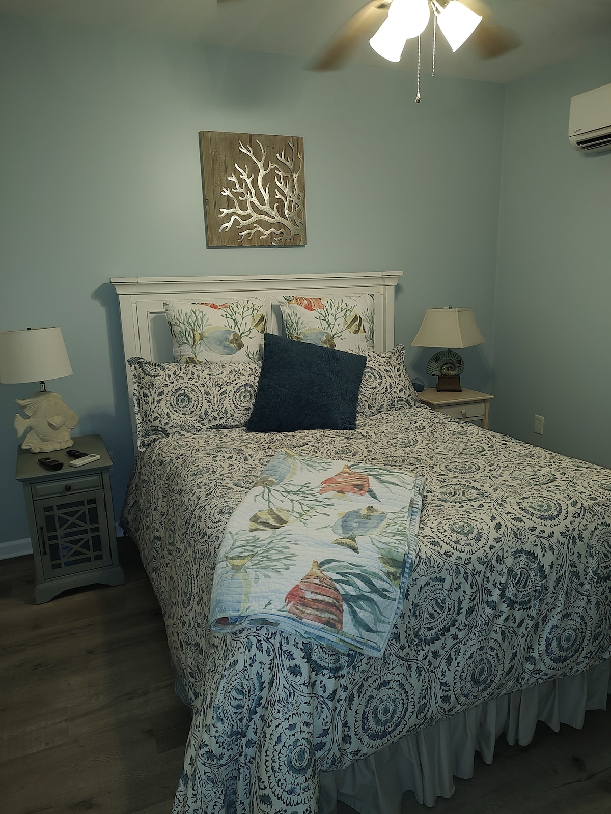 Dormitorio con cama queen y TV inteligente.