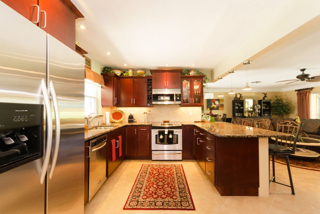 Modern kitchen with stainless appliances, granite, and eat in bar seating for 4
